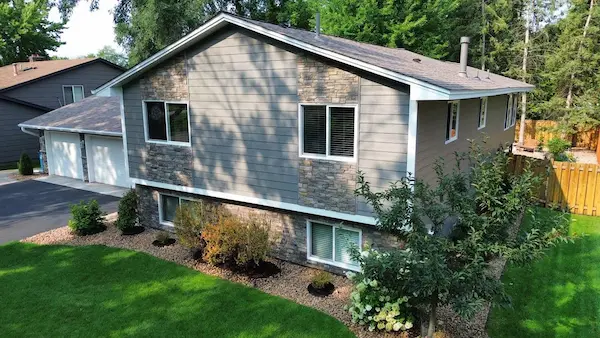 Full exterior renovation with Hardie siding, Versetta Stone, new roofing, windows, doors, soffit, fascia, and gutters in Champlin, MN