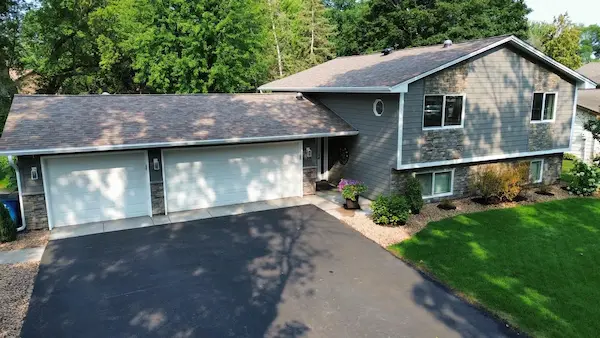 Full exterior renovation with Hardie siding, Versetta Stone, new roofing, windows, doors, soffit, fascia, and gutters in Champlin, MN