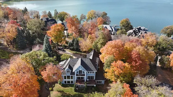 Wide aerial view of a completed Brava composite roof surrounded by fall foliage in Mound, MN