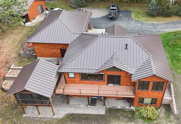 Custom-bent standing seam metal roof installation on a home with complex rooflines in Aitkin, MN