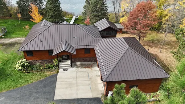 Completed custom standing seam metal roofing with a dark finish on a home in Aitkin, MN