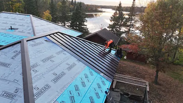 Close aerial view of roofing underlayment and installation work for a custom standing seam metal roof in Aitkin, MN