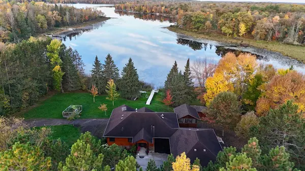 Wide drone view of a custom standing seam metal roof on a residential property near a lake in Aitkin, MN