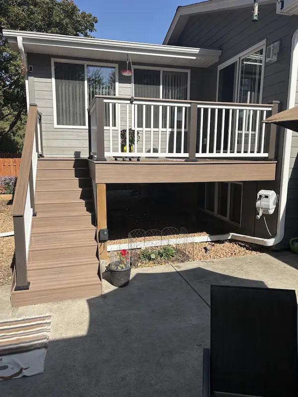 Elevated TimberTech Advanced PVC deck installation with stairs and contrasting railing on a home in Champlin, MN