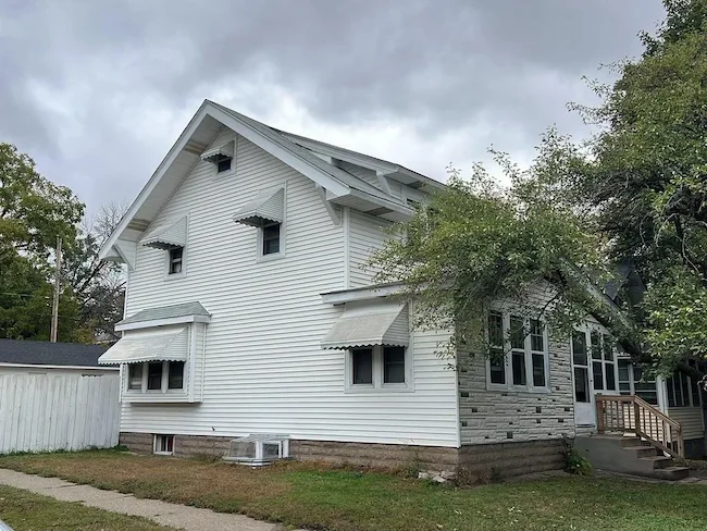 Before storm damage restoration with damaged siding and roof